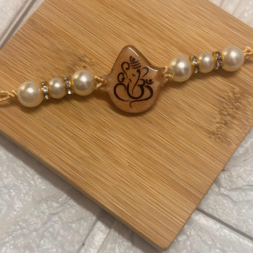 resin rakhi with Ganesh design and pearl beads